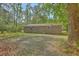 Brick home's spacious backyard with mature trees and a lawn covered in fallen leaves at 202 Oak Cir, Walterboro, SC 29488