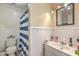 Bathroom featuring blue striped shower curtain, white tile walls and vanity with framed mirror at 202 Oak Cir, Walterboro, SC 29488