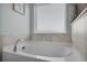 Soaking tub with tiled surround and frosted window at 204 Honey Horn Dr, Summerville, SC 29486