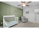 Inviting Bedroom showcases a decorative wall, crib, and comfy gray glider beneath a ceiling fan at 204 Honey Horn Dr, Summerville, SC 29486