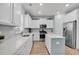 Bright kitchen features stainless steel appliances, white cabinets, and a blue island with light wood flooring at 204 Honey Horn Dr, Summerville, SC 29486