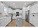 Updated kitchen features white cabinets, stainless steel appliances, an island with seating, and wood flooring at 204 Honey Horn Dr, Summerville, SC 29486