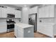 Updated kitchen features white cabinets, stainless steel appliances, an island with seating, and wood flooring at 204 Honey Horn Dr, Summerville, SC 29486