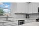 A bright kitchen features stainless steel appliances, a white backsplash, and quartz countertops at 204 Honey Horn Dr, Summerville, SC 29486