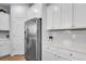 An open kitchen design with stainless steel appliances, white cabinets and backsplash, and neutral countertops at 204 Honey Horn Dr, Summerville, SC 29486