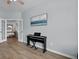 Bright living room features wood-look floors, a black electric piano, and modern french doors leading to the entryway at 204 Honey Horn Dr, Summerville, SC 29486