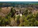 Aerial view showcasing the property, including a pond, guest house, and wooded areas at 2042 Highway 402, Moncks Corner, SC 29461