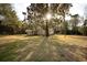 Expansive backyard featuring mature trees and a well-maintained lawn, creating a serene and private outdoor space at 2042 Highway 402, Moncks Corner, SC 29461