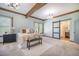 This cozy bedroom features exposed wood beams and an en-suite bathroom with a sliding barn door at 2042 Highway 402, Moncks Corner, SC 29461