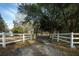 A long driveway leads to a property with a gated entrance and lush mature trees at 2042 Highway 402, Moncks Corner, SC 29461