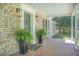 Inviting front porch with brick facade, decorative plants, and a cozy 