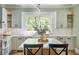 Bright kitchen with a farmhouse sink, green cabinetry, and a center island with stone countertops at 2042 Highway 402, Moncks Corner, SC 29461