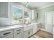 Bright kitchen featuring white countertops, apron sink and light green cabinets at 2042 Highway 402, Moncks Corner, SC 29461