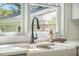 Close up of farmhouse kitchen sink and modern fixtures beneath a bright window with greenery views at 2042 Highway 402, Moncks Corner, SC 29461