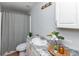 Well-lit bathroom features a shower with gray curtain, granite countertop, and white cabinets at 208 Langham Ct, Moncks Corner, SC 29461