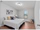 A cozy bedroom featuring a comfortable bed with stylish pillows, a window with blinds, and wood-look flooring at 208 Langham Ct, Moncks Corner, SC 29461