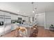 Bright kitchen with white cabinets, stainless steel appliances, and an island with a sink and bar stool seating at 208 Langham Ct, Moncks Corner, SC 29461
