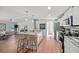 Well-lit kitchen with stainless steel appliances, an island with seating, and an open layout to the adjacent living area at 208 Langham Ct, Moncks Corner, SC 29461