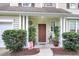 Close-up of the front porch featuring a charming front door, potted plants, and a welcoming sign at 2136 Baldwin Park Dr, Mount Pleasant, SC 29466