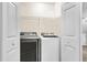 A clean laundry room area featuring a front-load washer and dryer, and a wire shelf for storage at 2136 Baldwin Park Dr, Mount Pleasant, SC 29466