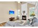 Bright and airy living room with fireplace, large windows, hardwood floors, comfortable sectional and flat screen TV at 2136 Baldwin Park Dr, Mount Pleasant, SC 29466