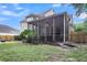 An exterior shot showcasing a cozy screened-in porch with a ceiling fan and view of the spacious, green backyard at 2136 Baldwin Park Dr, Mount Pleasant, SC 29466