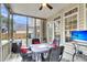 Relaxing screened porch with ceiling fan, dining table and chairs, TV and outdoor grill at 2136 Baldwin Park Dr, Mount Pleasant, SC 29466