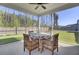 Screened in porch has a ceiling fan, outdoor table, and seating with a view of a fenced in yard at 222 Hayworth Rd, Summerville, SC 29486