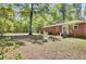 Expansive backyard featuring a well-maintained lawn, mature trees, and a brick home with an outdoor seating area at 237 Cypress Dr, Walterboro, SC 29488