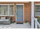 Close up of blue front door and seating on the charming, brick front porch at 237 Cypress Dr, Walterboro, SC 29488