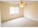 A well-lit bedroom with neutral carpet, ceiling fan, and a window with blinds at 2402 Riverridge Ct, Moncks Corner, SC 29461