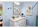 Charming bathroom with marble countertop vanity, blue walls, and decorative coastal artwork enhancing the space at 2413 Racquet Club Dr, Seabrook Island, SC 29455