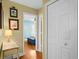 Hallway featuring hardwood floors and a view into a bedroom, complemented by a quaint decorative table at 2413 Racquet Club Dr, Seabrook Island, SC 29455