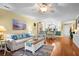 Cozy living room with hardwood floors, ceiling fan, and nautical-themed decor, leading into dining area at 2413 Racquet Club Dr, Seabrook Island, SC 29455