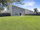 Sprawling backyard features lush green grass, privacy fencing, and the rear of the home with a sliding glass door at 243 Donatella Dr, Goose Creek, SC 29445