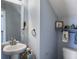 Cozy powder room features a pedestal sink, toilet, blue walls, and decorative shelves at 243 Donatella Dr, Goose Creek, SC 29445