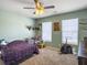 Cozy bedroom featuring green walls, carpet, ceiling fan with light, and two windows at 243 Donatella Dr, Goose Creek, SC 29445
