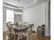Bright dining area featuring a large table with seating for six, a chandelier, and tray ceiling at 243 Donatella Dr, Goose Creek, SC 29445