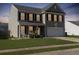 Charming two-story home with a well-manicured lawn and inviting front porch at dusk at 243 Donatella Dr, Goose Creek, SC 29445