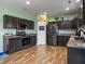 Spacious kitchen flowing into the living area, featuring dark cabinets and hardwood floors at 243 Donatella Dr, Goose Creek, SC 29445