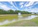 Scenic pond with a fountain surrounded by lush greenery and blue skies at 255 Longford Dr, Summerville, SC 29483