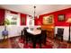Inviting dining room featuring vibrant red walls, a marble-topped table, and a charming piano at 29 Meander Row, Charleston, SC 29412