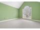 Bright, empty bedroom with green walls, light patterned carpeting, and a rounded window at 298 Hook Ln, Mount Pleasant, SC 29464