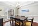 An inviting dining room is adorned with a stylish chandelier, ample natural light, and traditional wainscoting at 298 Hook Ln, Mount Pleasant, SC 29464