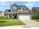 Charming two-story home with stone accents, landscaped yard, and a two-car garage at 306 Todder Trl, Goose Creek, SC 29445