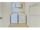 Convenient laundry room with a side-by-side washer and dryer set, metal storage shelves, and a clean, tiled floor at 346 Iveson Rd, Summerville, SC 29486