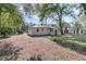 View of a charming one-story home featuring a spacious backyard, mature trees, and side patio area at 3484 Johan Blvd, Johns Island, SC 29455