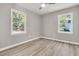 Bright bedroom features two large windows, modern ceiling fan, and beautiful wood flooring at 3484 Johan Blvd, Johns Island, SC 29455