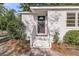 Close up of entrance to cozy home with black front door, white trim, and lovely landscaping at 3484 Johan Blvd, Johns Island, SC 29455