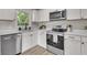 Bright kitchen with stainless steel appliances, white cabinets, countertops, and wood-look flooring at 3484 Johan Blvd, Johns Island, SC 29455